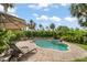 A beautiful kidney-shaped pool with a jacuzzi and plenty of room for lounging surrounded by tropical landscaping at 58 Aster St, Clearwater Beach, FL 33767