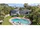 Aerial view of a private backyard featuring a beautiful pool, spa, lush landscaping, and outdoor seating areas at 58 Aster St, Clearwater Beach, FL 33767