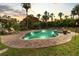 A beautifully lit kidney-shaped pool with a jacuzzi and plenty of room for lounging surrounded by tropical landscaping at 58 Aster St, Clearwater Beach, FL 33767