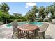 Relaxing poolside patio with a table set for two near the beautiful pool, palm trees, and lush landscaping at 58 Aster St, Clearwater Beach, FL 33767