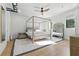 Bright bedroom with a four-poster bed, neutral decor, and hardwood floors at 5816 S 3Rd St, Tampa, FL 33611
