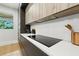 Close-up of a kitchen featuring a modern cooktop, sleek countertops, and designer backsplash at 5816 S 3Rd St, Tampa, FL 33611
