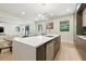 Bright, modern kitchen featuring a spacious island with a sink, stainless appliances, and open access to the living area at 5816 S 3Rd St, Tampa, FL 33611