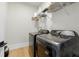 Functional laundry room with modern, dark-colored washer and dryer and practical shelving for supplies at 5816 S 3Rd St, Tampa, FL 33611