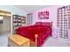 Cozy bedroom with vibrant wall decor, bookshelves, and view into the bathroom at 6231 Olivedale Dr, Riverview, FL 33578