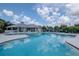 Large community pool with plenty of seating, surrounded by a clubhouse, playground, and lush landscaping at 6231 Olivedale Dr, Riverview, FL 33578