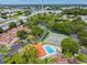 Aerial view of community featuring tennis courts, pool, green spaces, and mature trees at 6262 142Nd N Ave # 1302, Clearwater, FL 33760