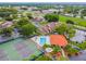 This aerial view highlights the pool and tennis court amenities, surrounded by lush landscaping at 6262 142Nd N Ave # 1302, Clearwater, FL 33760