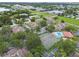 This aerial view shows a community with amenities including a pool, tennis court, and mature trees at 6262 142Nd N Ave # 1302, Clearwater, FL 33760