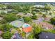 A serene aerial view showcasing the pool and tennis court surrounded by lush greenery at 6262 142Nd N Ave # 1302, Clearwater, FL 33760