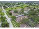 This aerial shows a residential area with mature trees and a nearby tennis court and swimming pool at 6262 142Nd N Ave # 1302, Clearwater, FL 33760