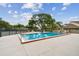 Community pool surrounded by lush greenery with seating for residents' enjoyment at 6262 142Nd N Ave # 1302, Clearwater, FL 33760