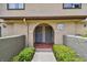 Charming condo entrance featuring a welcoming archway, gray doors, and lush green landscaping at 6262 142Nd N Ave # 1302, Clearwater, FL 33760