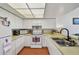 Bright kitchen features white cabinetry, stainless sink and appliances at 6262 142Nd N Ave # 1302, Clearwater, FL 33760
