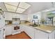 Bright kitchen features white cabinetry, stainless sink and appliances, and lots of natural light at 6262 142Nd N Ave # 1302, Clearwater, FL 33760