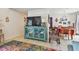 Cozy interior showcasing a display cabinet, TV, colorful area rug, and adjacent dining area at 6262 142Nd N Ave # 1302, Clearwater, FL 33760
