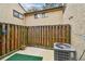 Enclosed patio area features a weathered wood fence, green turf, and partial view of the air conditioner unit at 6262 142Nd N Ave # 1302, Clearwater, FL 33760