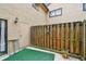 Small enclosed patio includes weathered wood fence with string lights, green turf, and an access door at 6262 142Nd N Ave # 1302, Clearwater, FL 33760