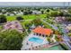 Aerial view of a community pool and tennis court, surrounded by lush landscaping and trees at 6262 142Nd N Ave # 1302, Clearwater, FL 33760