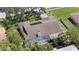 Aerial view of home with screened-in pool, solar panels and fenced in yard, nestled among mature trees at 6706 Dunes Ln, Temple Terrace, FL 33617