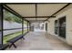 Spacious covered patio area with stone flooring, ideal for outdoor seating and entertaining near the pool at 6706 Dunes Ln, Temple Terrace, FL 33617