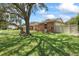Well-maintained home showcasing a spacious lawn, brick exterior, and a privacy fence at 6706 Dunes Ln, Temple Terrace, FL 33617