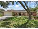 Charming single-story home featuring lush landscaping, brick accents, and solar panels for energy efficiency at 6706 Dunes Ln, Temple Terrace, FL 33617