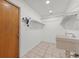 Functional utility room with a sink, tiled floor, and shelving, offering practical storage solutions at 6706 Dunes Ln, Temple Terrace, FL 33617