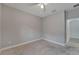 Cozy bedroom featuring neutral gray walls, plush carpet, and a ceiling fan for added comfort at 7408 Sungold Meadow Ct, Apollo Beach, FL 33572