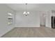 Dining room with stylish chandelier, light wood flooring, and detailed wall paneling that offers a modern touch at 7408 Sungold Meadow Ct, Apollo Beach, FL 33572