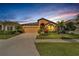 Inviting single-story home with a two-car garage and tropical landscaping at sunset at 7408 Sungold Meadow Ct, Apollo Beach, FL 33572