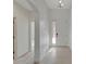 Bright hallway with white walls and tiled flooring leading to the front door, providing a welcoming entrance at 7408 Sungold Meadow Ct, Apollo Beach, FL 33572