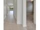 Hallway with tiled flooring leading to the kitchen and dining area, offering an easy flow between spaces at 7408 Sungold Meadow Ct, Apollo Beach, FL 33572