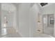 Light-filled hallway with access to the laundry room, tiled flooring, and view of the front entrance at 7408 Sungold Meadow Ct, Apollo Beach, FL 33572