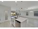 Spacious kitchen island with a stainless steel dishwasher and sink and open-concept to living room at 7408 Sungold Meadow Ct, Apollo Beach, FL 33572
