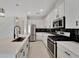 Modern kitchen with white cabinets, stainless steel appliances, and sleek black backsplash at 7408 Sungold Meadow Ct, Apollo Beach, FL 33572