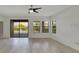 Bright living room features light wood floors, fan, and sliding glass doors at 7408 Sungold Meadow Ct, Apollo Beach, FL 33572