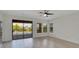 Bright living room features light wood floors, fan, and sliding glass doors to the pool area at 7408 Sungold Meadow Ct, Apollo Beach, FL 33572