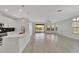 Open-concept living area with island seating, sleek appliances, and sliding doors to the pool, perfect for entertaining at 7408 Sungold Meadow Ct, Apollo Beach, FL 33572
