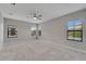 Spacious main bedroom with three bright windows, neutral paint, carpet, and a ceiling fan at 7408 Sungold Meadow Ct, Apollo Beach, FL 33572