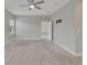 Bright primary bedroom featuring carpet, a ceiling fan, two windows, and an interior door at 7408 Sungold Meadow Ct, Apollo Beach, FL 33572
