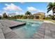 A stunning pool with cool blue water, complemented by contemporary gray pavers and manicured landscaping at 7408 Sungold Meadow Ct, Apollo Beach, FL 33572