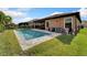 The backyard features an inviting pool, lush landscaping, and a covered patio at 7408 Sungold Meadow Ct, Apollo Beach, FL 33572