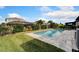 A private backyard pool is surrounded by lush landscaping, complemented by a sturdy iron fence at 7408 Sungold Meadow Ct, Apollo Beach, FL 33572