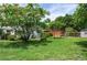 Lush backyard featuring mature trees providing shade and an orange storage shed at 760 72Nd N Ave, St Petersburg, FL 33702