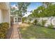 Well-maintained backyard featuring a brick paver walkway, grass, and various tropical plants at 8010 Par N Ave, St Petersburg, FL 33710