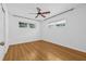 Bright bedroom featuring hardwood floors, a ceiling fan, and natural light from two windows at 8010 Par N Ave, St Petersburg, FL 33710