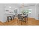 Open-concept dining area with modern light fixture and a view into the updated, white kitchen at 8010 Par N Ave, St Petersburg, FL 33710