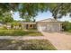 Charming single-story home with lush landscaping, brick driveway, and a two-car garage at 8010 Par N Ave, St Petersburg, FL 33710