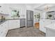 Bright kitchen with white cabinets, stainless steel appliances, and access to the open-concept dining room at 8010 Par N Ave, St Petersburg, FL 33710